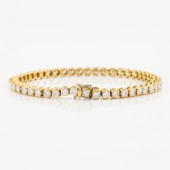 A tennis bracelet in 14K gold with round brilliant-cut diamonds.