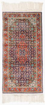 An oriental silk rug, c. 124 x 62 cm.