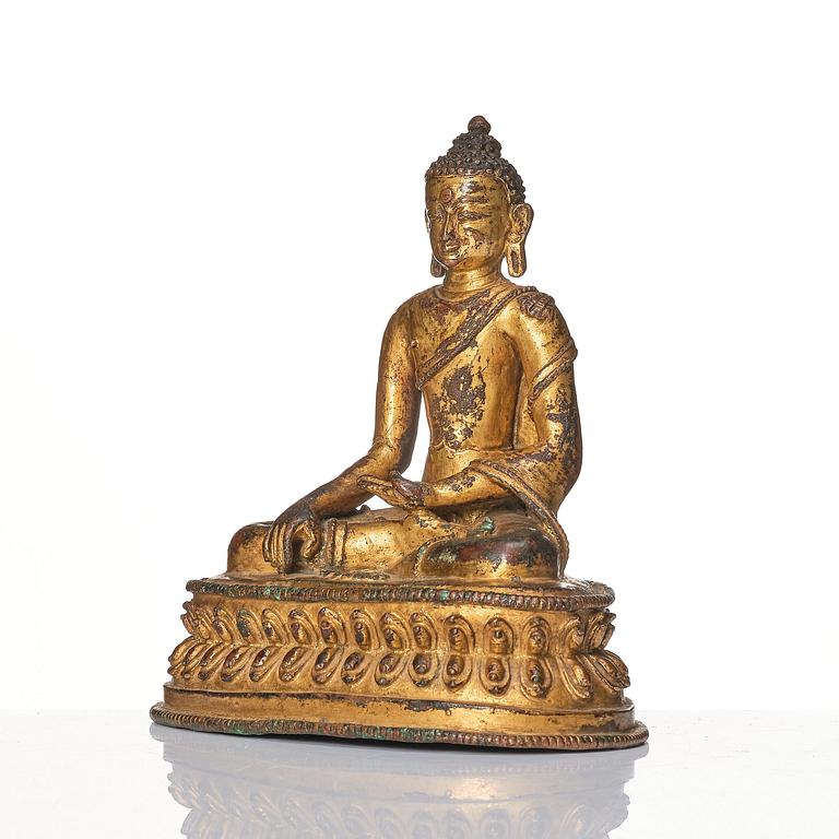 A gilt copper alloy figure of Buddha, Tibet/Nepal 15th Century.