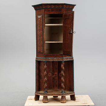 A painted corner cabinet, dated 1778.