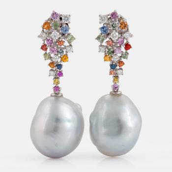 967. A pair of cultured drop shaped South Sea pearl earrings set with sapphires.