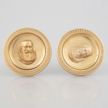 A pair of gilt-bronze Empire-style curtain holders, 19th century.