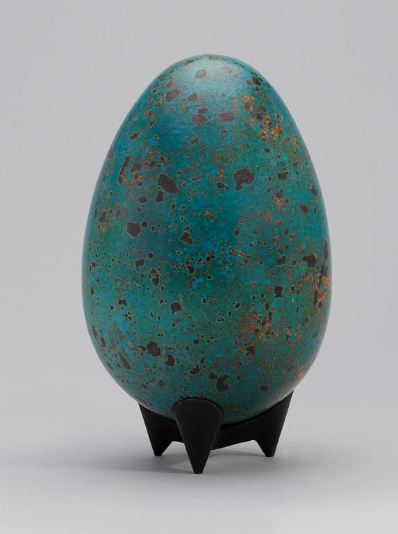 A Hans Hedberg faience egg on an iron stand, Biot, France.