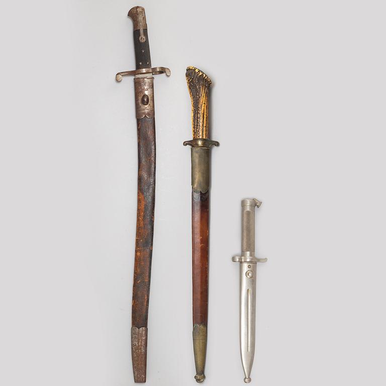 A hunting sword and two bayonets with scabbards.