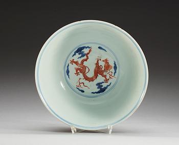 A blue and white bowl with a dragon in copper red, Qing dynasty with Xuande six character mark.