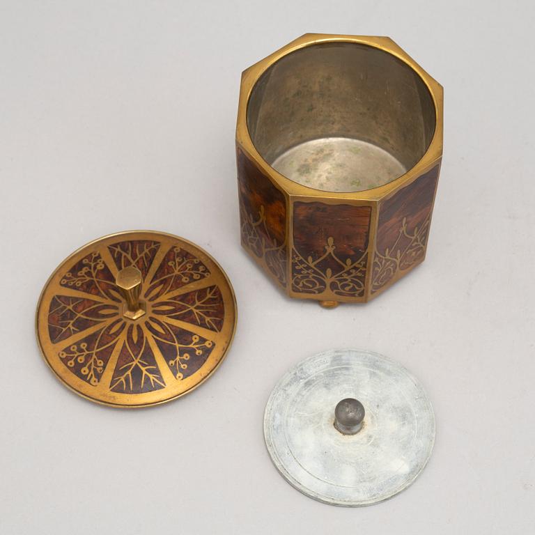 An art nouveau brass and burr walnut tobacco jar and cover from around year 1900.