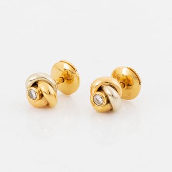 A pair of 18K gold Cartier "Trinity" earrings set with round brilliant-cut diamonds.