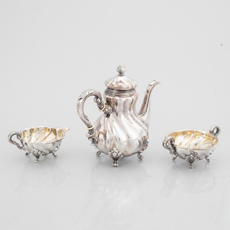 A Rococo Style Silver Coffee Pot, Creamer and Sugar Bowl, 20th Century, Swedish import mark.