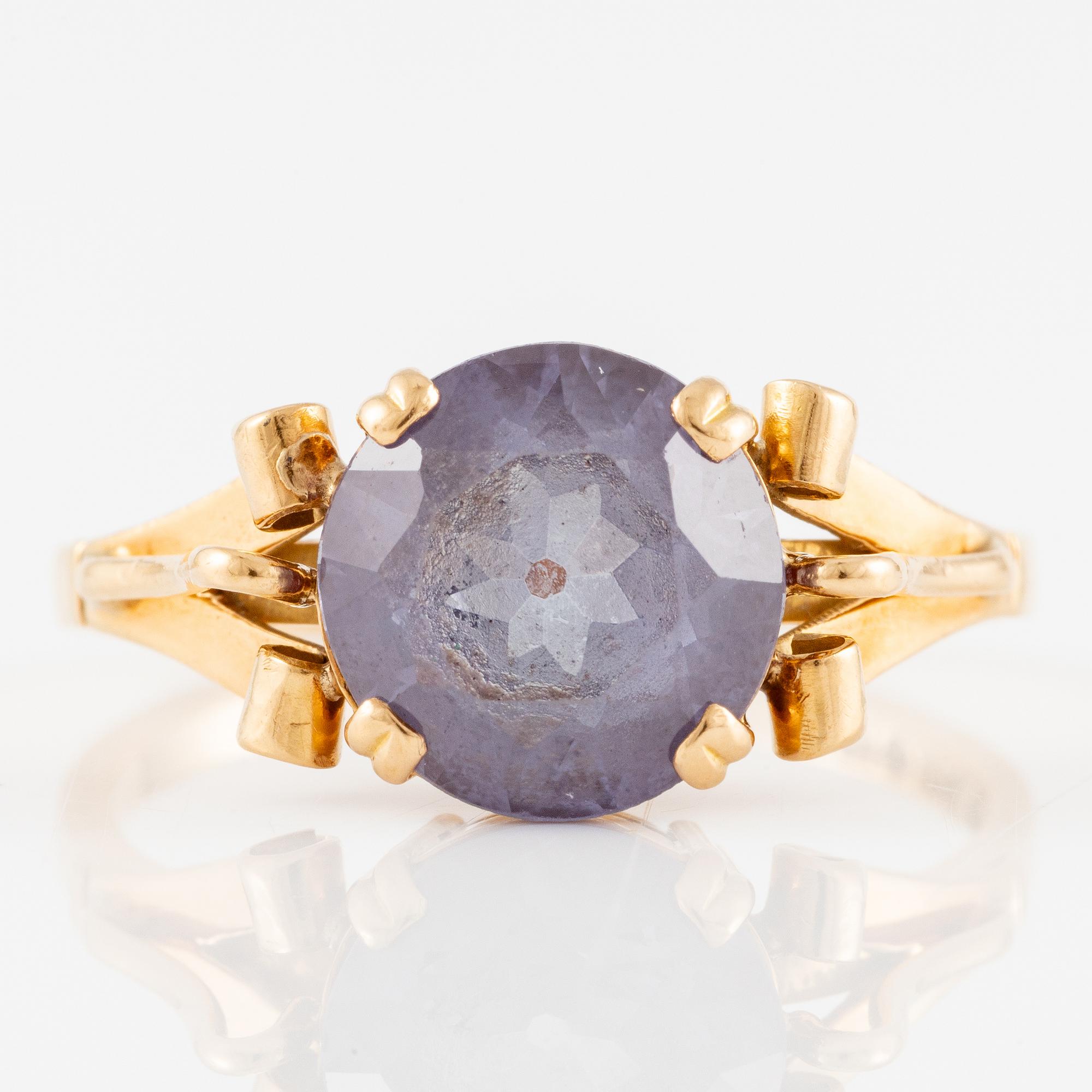 Ring 18K gold with a purple stone.
