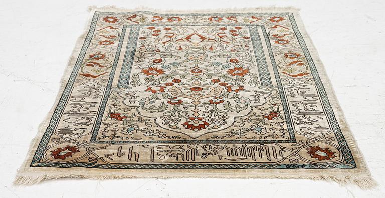 A Hereke silk rug, c. 73 x 52 cm.