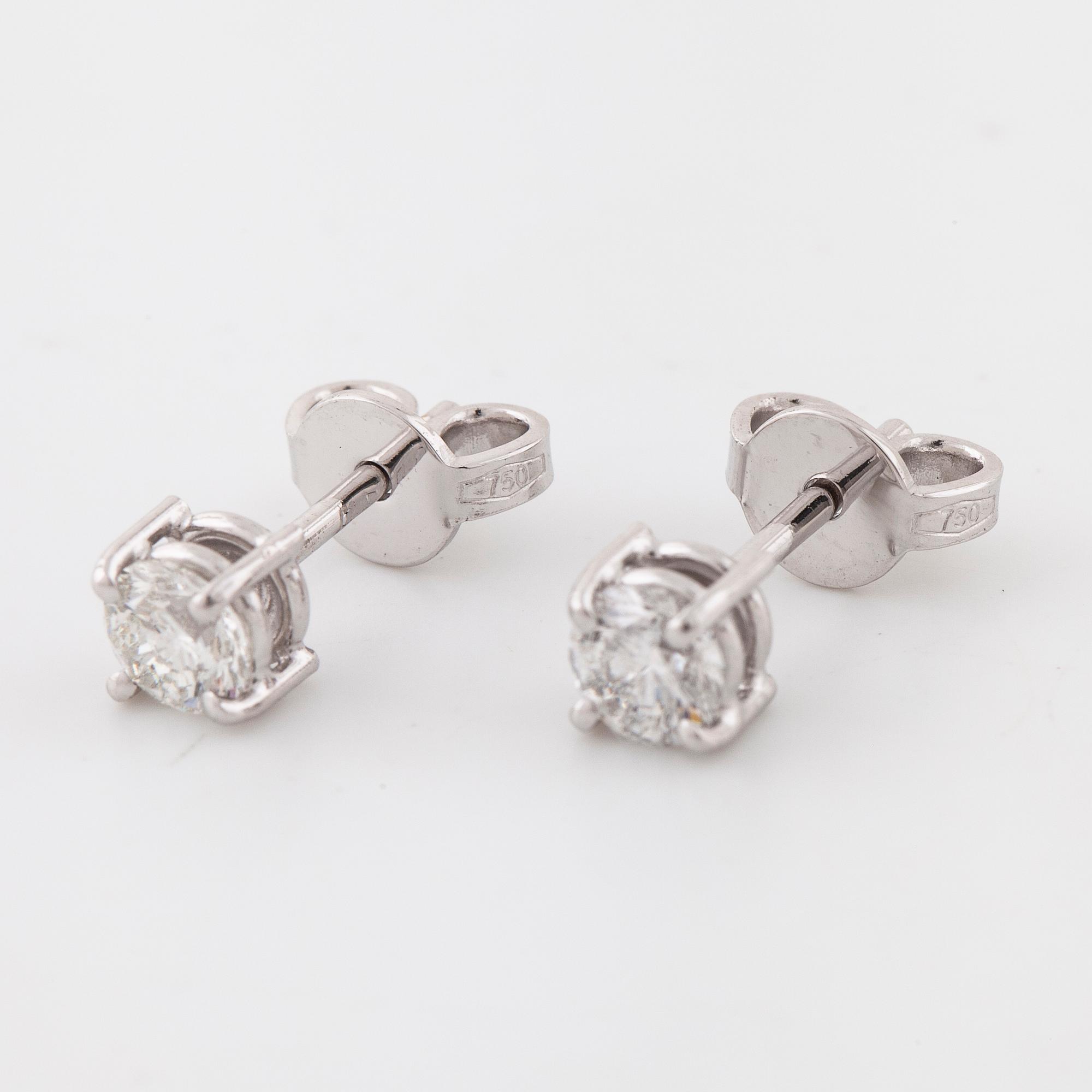 A pair of brilliant cut diamond earrings.