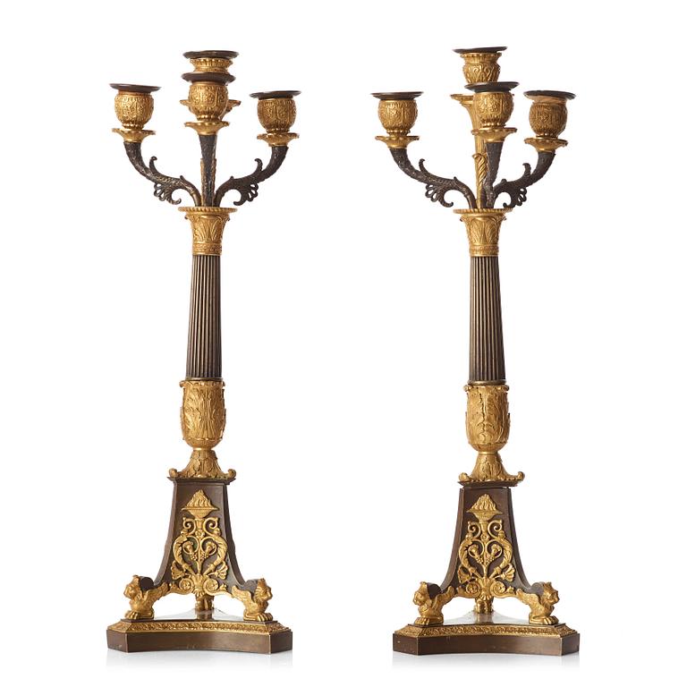 A pair of French Empire early 19th century gilt and patinated bronze four-light candelabra.