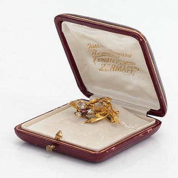 A 14K gold brooch set with rose-cut diamonds and a ruby.
