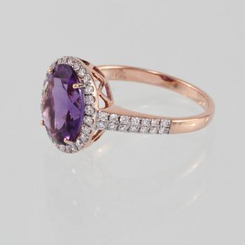 RING, 18K guld med briljantslipade diamanter 0.46 ct samt ovalslipad ametist. Vikt 3,5 gram.
