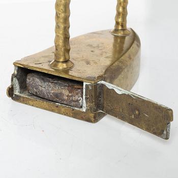A brass clothes' iron, dated 1773.