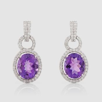 1269. A pair of amethyst and brilliant-cut diamond earrings.