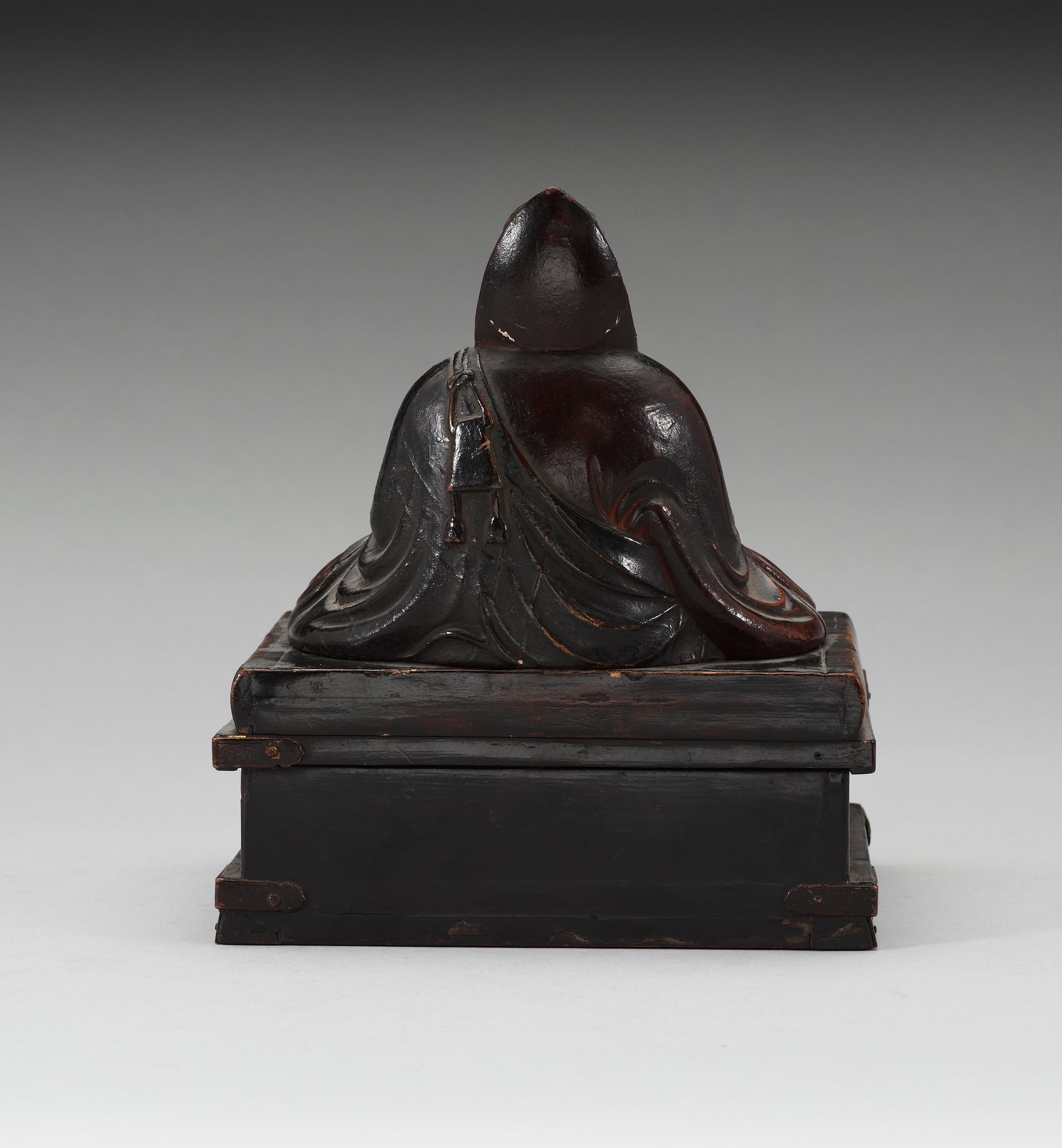A lacquered wooden Japanese deity on a stand, 19th Century.