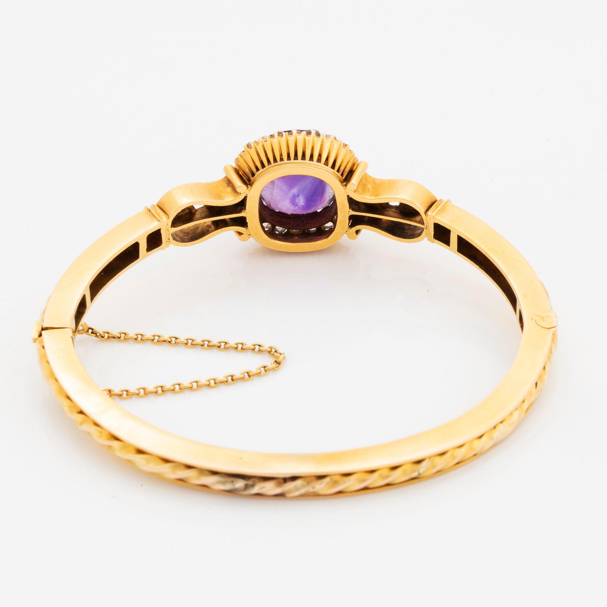 A 14K gold bangle set with a faceted amethyst and rose-and old-cut diamonds.