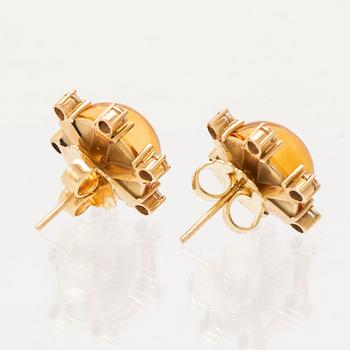 A pair of 18K gold earrings set with cabochon cut citrines and round brilliant cut diamonds.