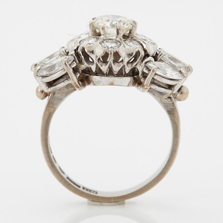 An 18K white gold ring set with round brilliant- and navette-cut diamonds.