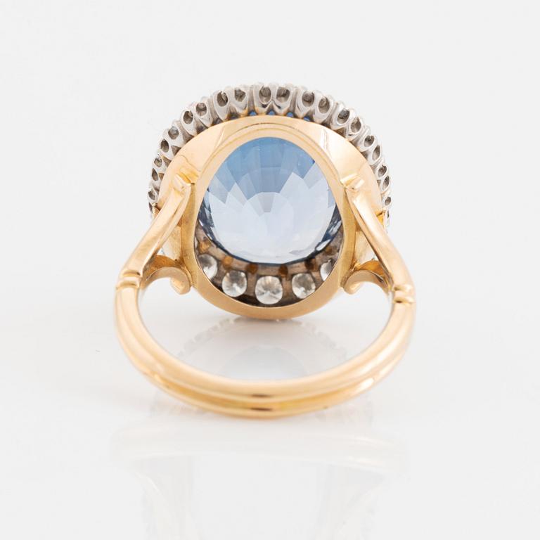 Ring 18K guld med en fasettslipad safir och runda briljantslipade diamanter.