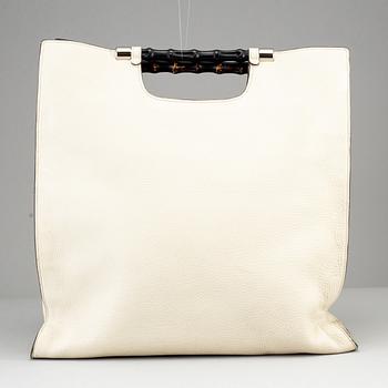 GUCCI, a white leather tote bag with bamboo handles.