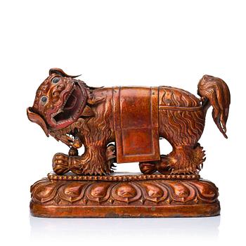 914. A cold gilt and lacquered copper alloy sculpture of a buddhist lion, Tibeto-Chinese/Mongolian, 18th Century.