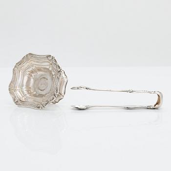 A silver sugar tong by Johan Warjus, and a silver salt cellar by Adolf Sper, St Petersburg 1856 and 1849.