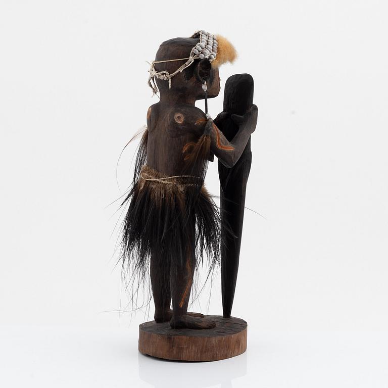 An Asmat carving of a woman holding an ax, Yamas, Jeni, 20th Century.