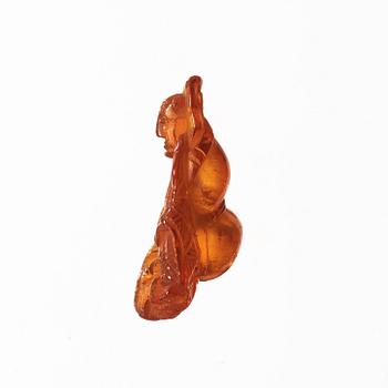 An amber pendant in the shape of a seated man, Qing dynasty (1644-1912).