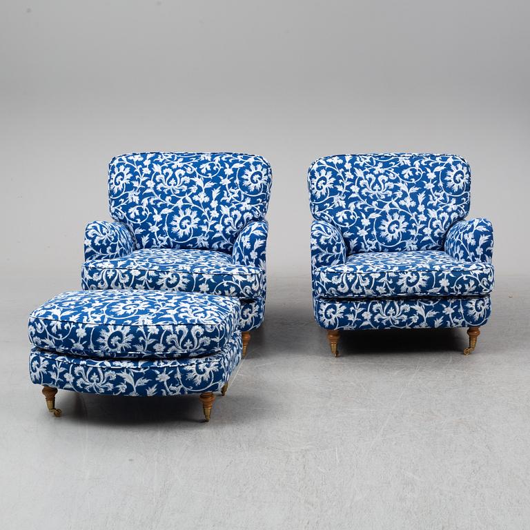 A pair of easy chairs and a stool.