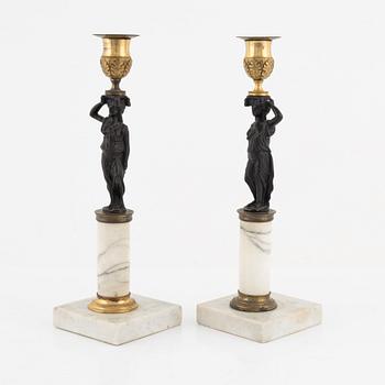 A pair of Gustavian-style ormolu, patinated bronze and marble candelsticks, circa 1900 incorporating older elements.