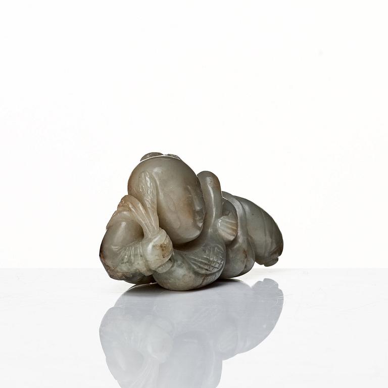 A neprite sculpture of a reclining boy with a duck, late Qing dynasty.