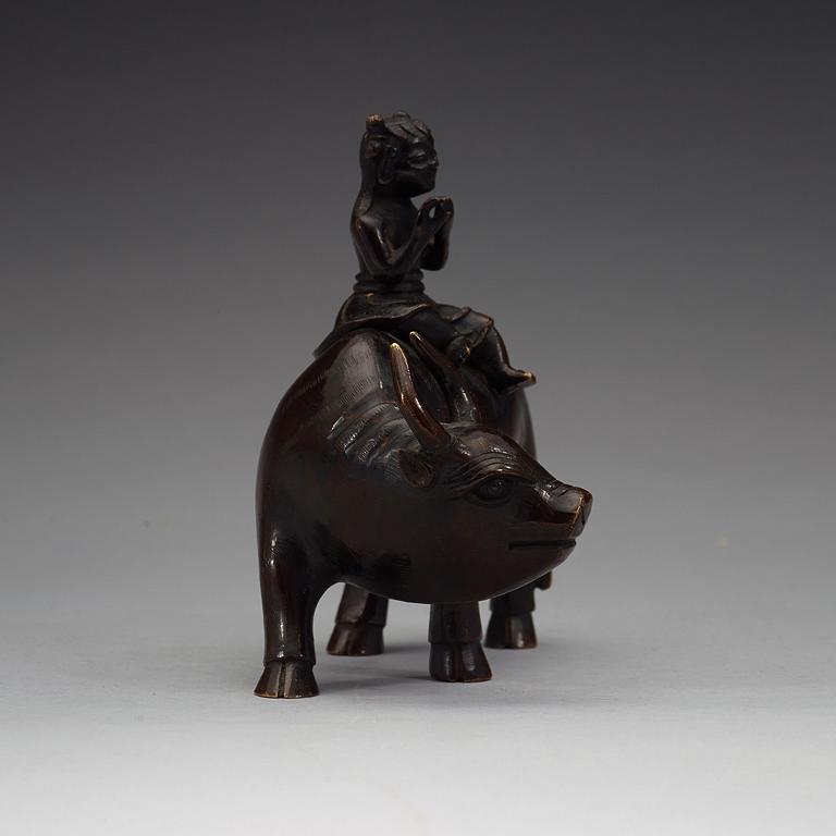 A bronze figure of a flute paying boy on a water buffalo, Qing dynasty (1644-1912).