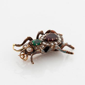 An antique 18K gold beetle brooch set with a faceted emerald and a garnet.