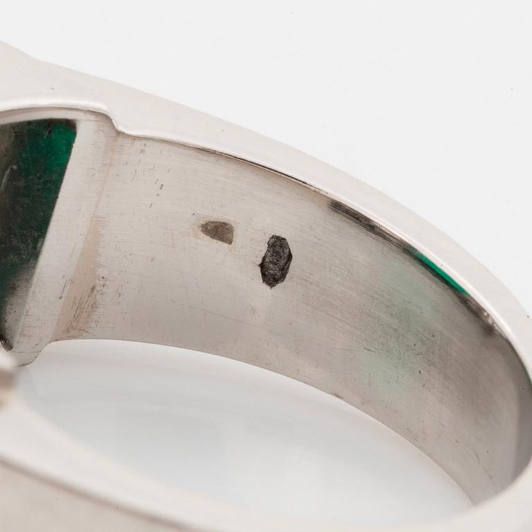 Ring platina med en trappslipad smaragd och runda briljant- och fasettslipade diamanter.