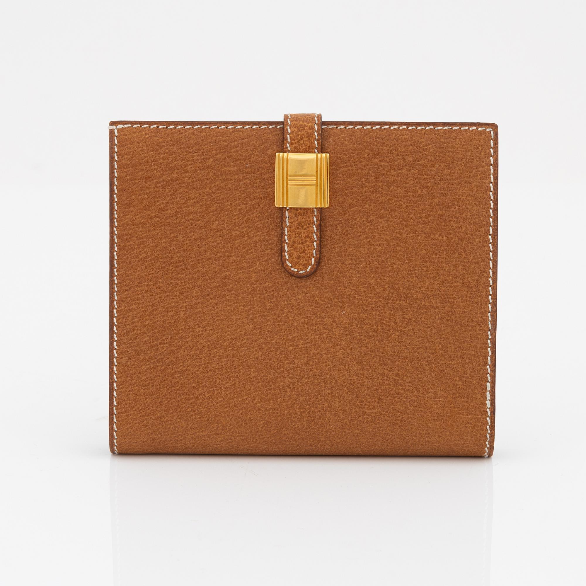 Hermès, a brown leather gold lock wallet.