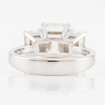 An 18K white gold ring set with three emerald-cut diamonds.