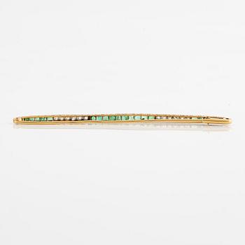 Brosch, längre modell, guld med carréslipade smaragder och gammalslipade diamanter, troligen omkring sekelskiftet 1900.