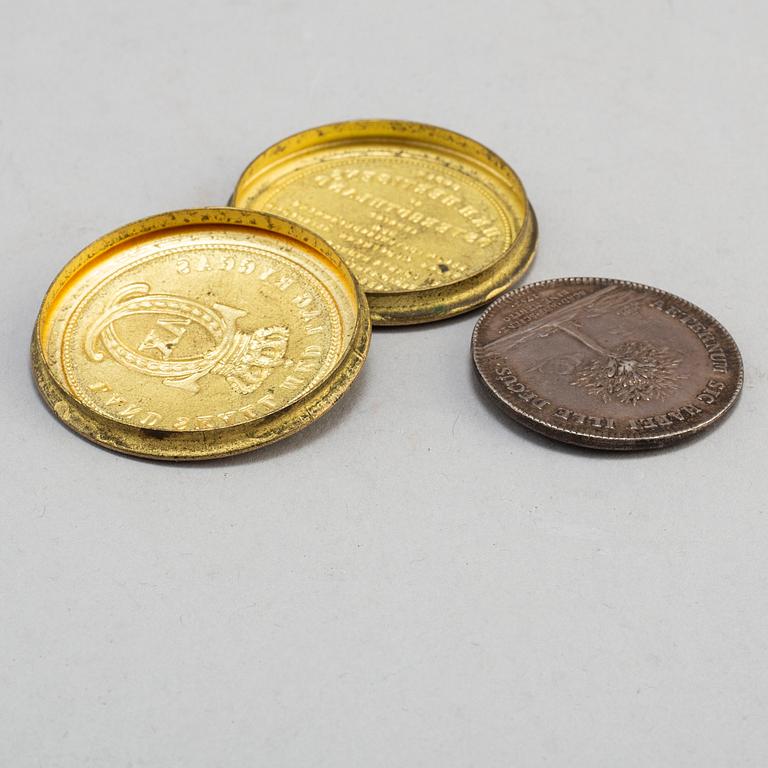A silver medal by Daniel Fehrman, 1753 and a guilded brass box from the Stockholm art- and handicraft exhibition 1866.