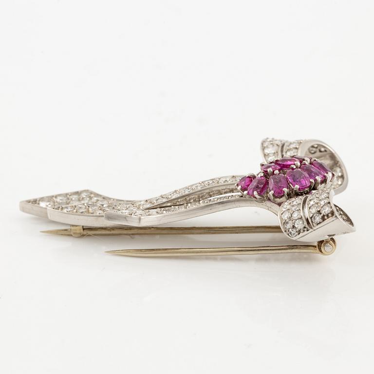 A brooch in platinum in the form of a bow with rubies and diamonds, likely from the 1950s.