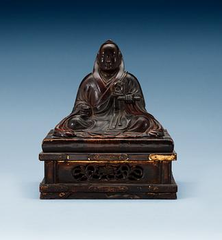 1706. A lacquered wooden Japanese deity on a stand, 19th Century.
