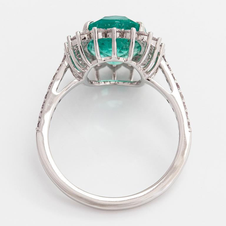 A 14K white gold ring, with an oval-cut emerald and diamonds. With IGI certificate.