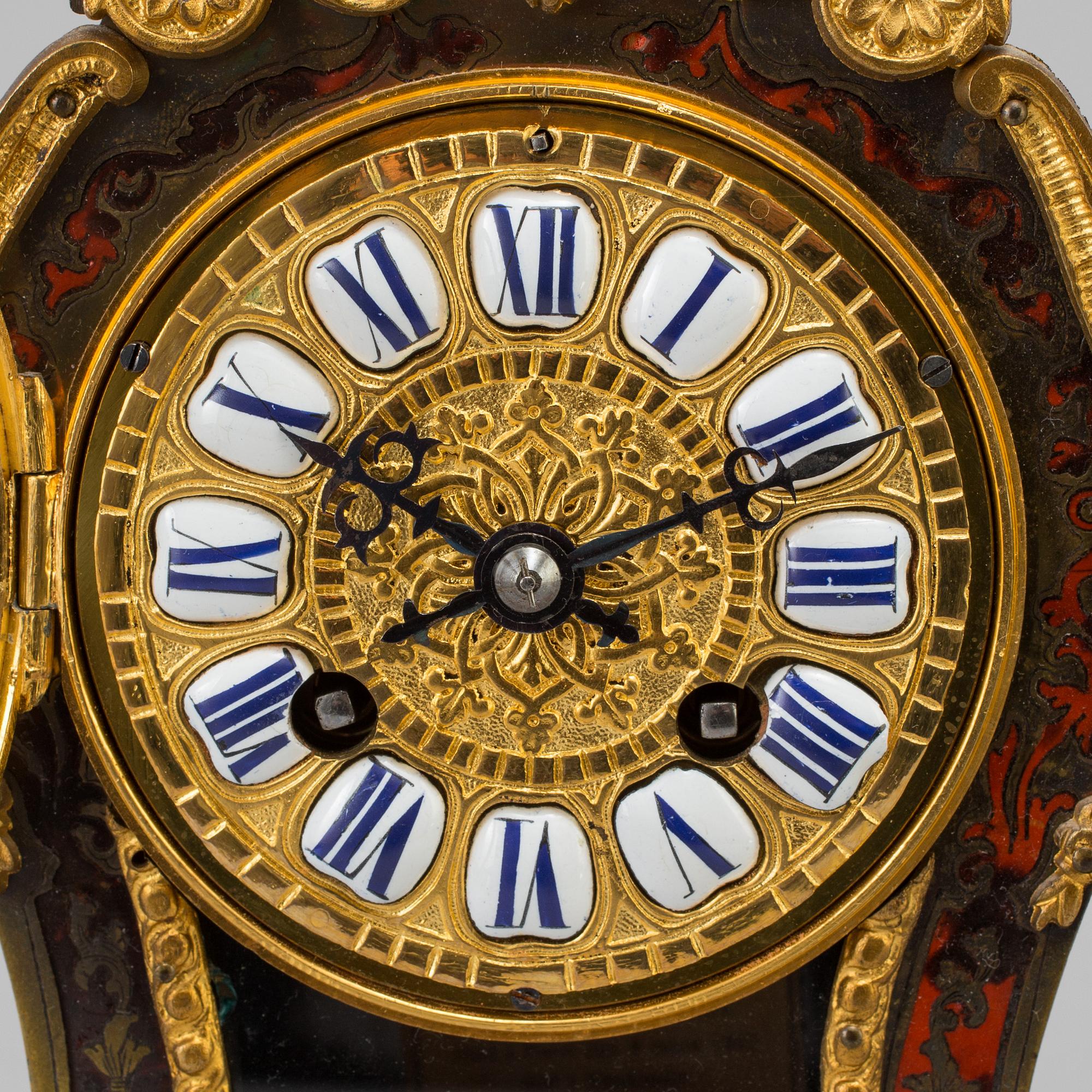 A Louis XV-style mantle clock with console base.