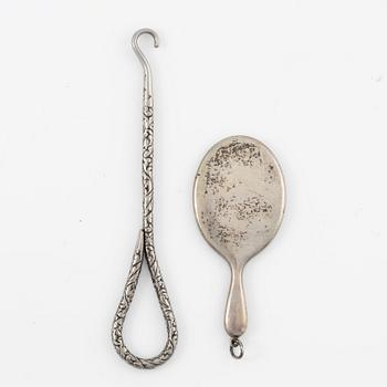 Two brushes, a hook, and a small mirror, silver and nickel silver.
