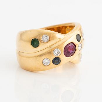 Ring in 18K gold with a faceted ruby, emerald, sapphire, and round brilliant-cut diamonds.