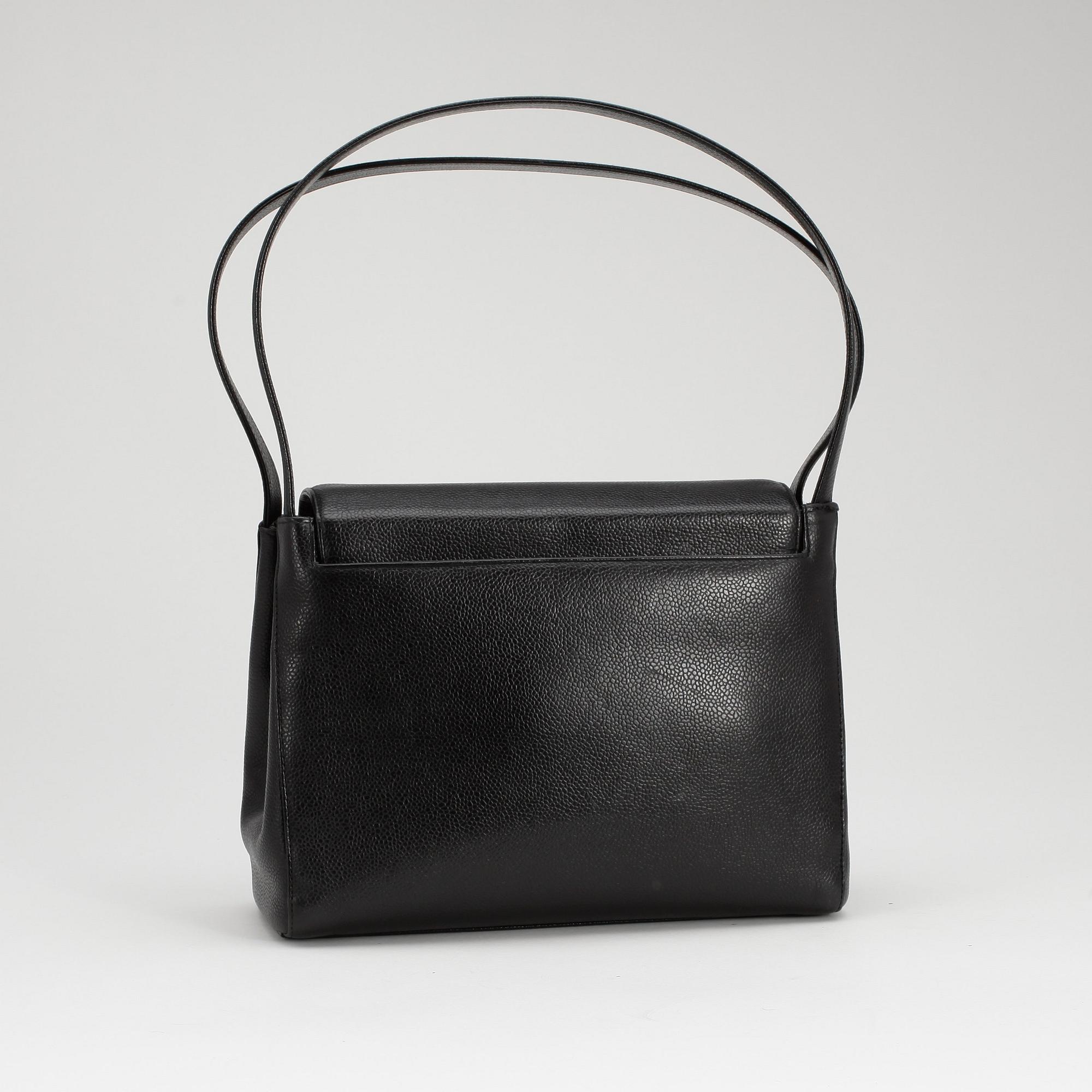 CHANEL, a black caviar leather shoulder bag with gold colored CC lock.