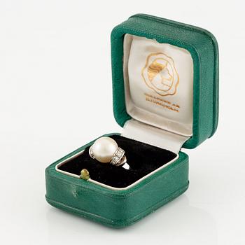 A ring in 18K white gold with a cultured pearl and round brilliant-cut diamonds.