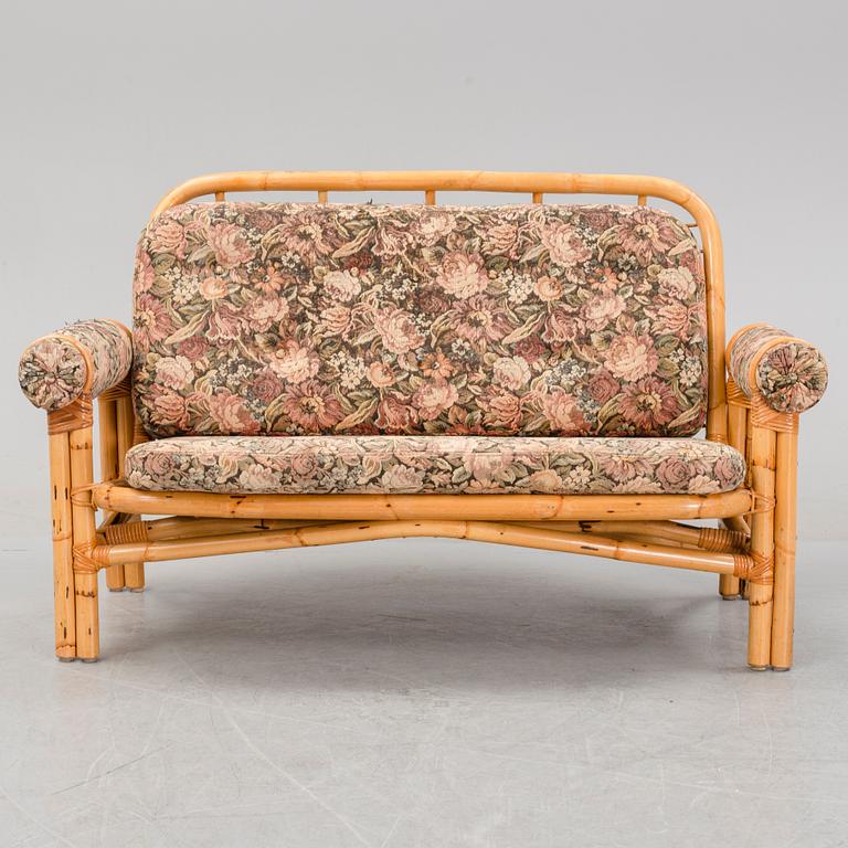 A set of two garden sofas, an armchair and a glass table, later part of the 20th Century.