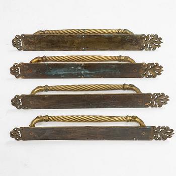 Four brass door handles, around 1900.